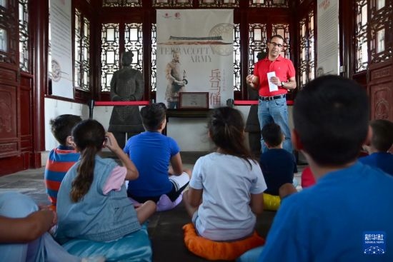 7月4日，在馬耳他桑塔露琪亞市的中國古典園林“靜園”，人們聆聽關(guān)于兵馬俑的講解。新華社發(fā)（喬納森·博格 攝）