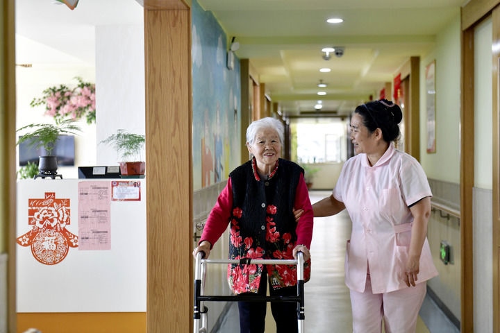 2024年5月25日，在山東省日照市東港區(qū)石臼街道日照幸福護(hù)理院，工作人員在陪護(hù)老人。新華社記者 郭緒雷 攝