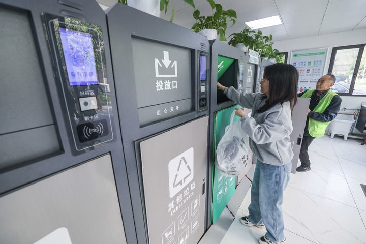 2024年4月10日，在浙江省湖州市吳興區(qū)飛英街道新華府小區(qū)內(nèi)，居民在垃圾分類(lèi)智能系統(tǒng)的指導(dǎo)下進(jìn)行垃圾分類(lèi)投放，居民的投放情況將實(shí)時(shí)匯總到智慧服務(wù)平臺(tái)，會(huì)有相應(yīng)的積分獎(jiǎng)勵(lì)。新華社記者 徐昱 攝