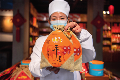 在位于山西省晉中市平遙縣的平遙古城南大街的一家平遙牛肉店內(nèi)，工作人員展示一款牛肉產(chǎn)品（資料照片）楊晨光攝 / 本刊