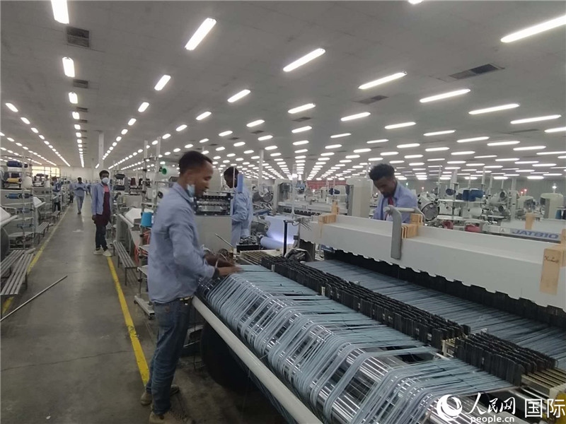 無錫金茂埃塞面料廠車間內(nèi)，當?shù)毓と苏谝唤z不茍地作業(yè)。人民網(wǎng)記者 黃培昭攝