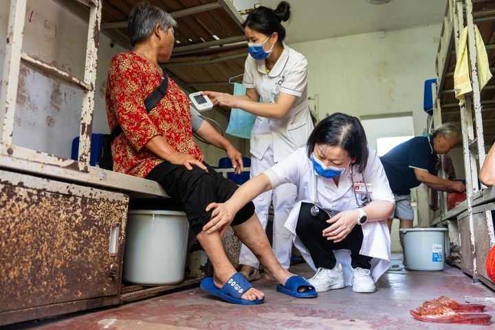 2024年7月30日，在湖南省湘潭縣河口中學安置點，醫(yī)務人員為受洪水影響而轉移安置的群眾檢查身體。 新華社記者 陳思汗 攝
