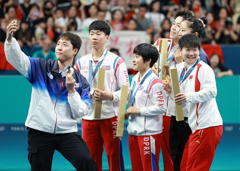 冠軍中國組合王楚欽（右三）/孫穎莎（右一）、亞軍朝鮮組合李正植（左二）/金琴英（左三）、季軍韓國組合林鐘勛（左一）/申裕斌在巴黎奧運會乒乓球混雙頒獎儀式上合影（2024年7月30日攝）。新華社記者 劉續(xù) 攝