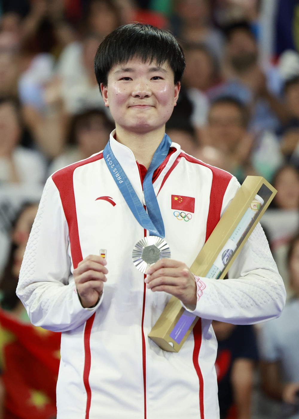 巴黎奧運會羽毛球女子單打亞軍、中國選手何冰嬌在頒獎儀式上一手握著銀牌，一手握著西班牙奧委會徽章（2024年8月5日攝）。新華社記者 任正來 攝