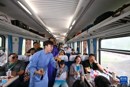 9月7日，相聲演員在S910列車上為旅客表演快板。