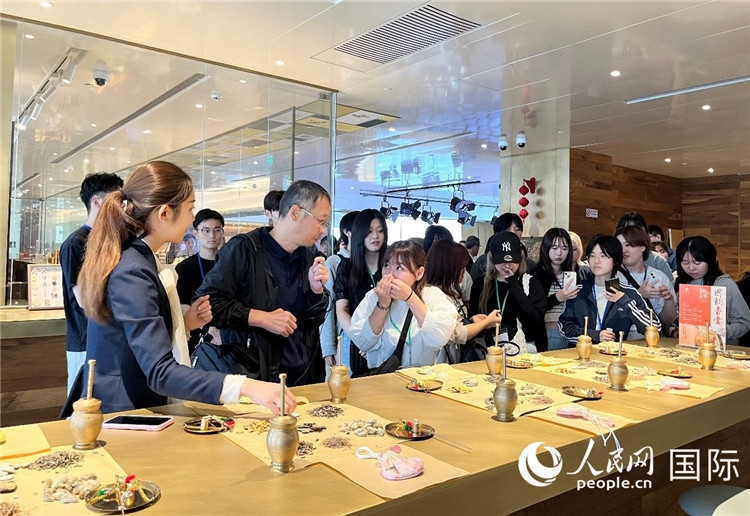 1. 日中友好協(xié)會青年代表團(tuán)一行學(xué)習(xí)中醫(yī)香囊制作工序。（人民網(wǎng)記者陳思 攝）