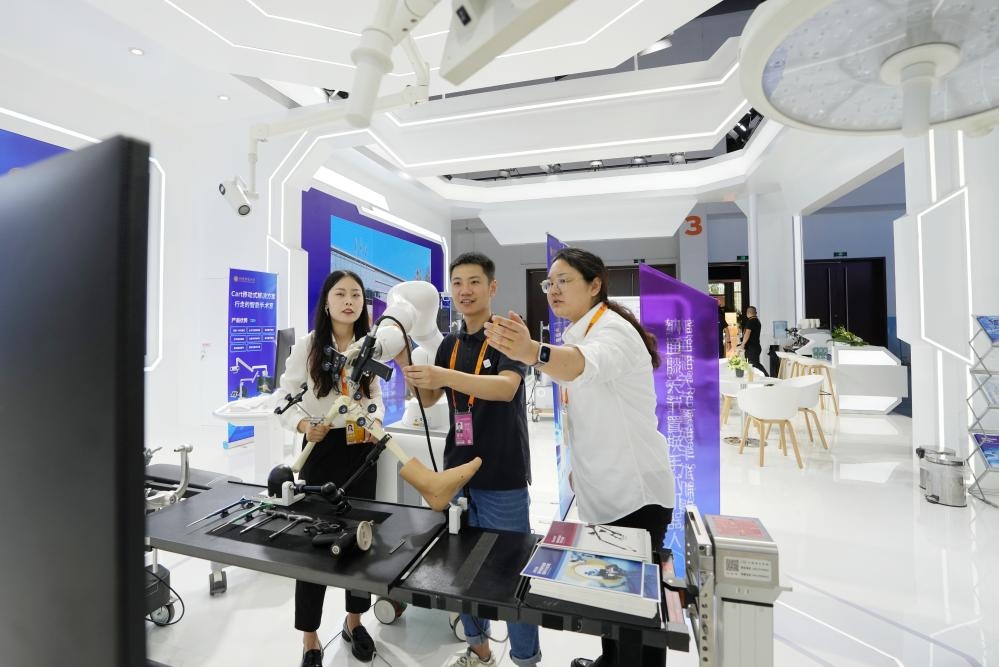 9月11日，一位媒體記者（中）在2024年服貿(mào)會(huì)國家會(huì)議中心會(huì)場(chǎng)體驗(yàn)北京納通科技集團(tuán)有限公司的膝關(guān)節(jié)置換手術(shù)機(jī)器人。新華社記者鞠煥宗 攝