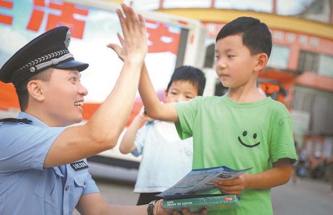 ▲7月10日，江西省吉安市公安局吉州分局組織民警深入轄區(qū)開展安全宣傳，民警向小朋友講解防溺水知識(shí)。朱文杰攝
