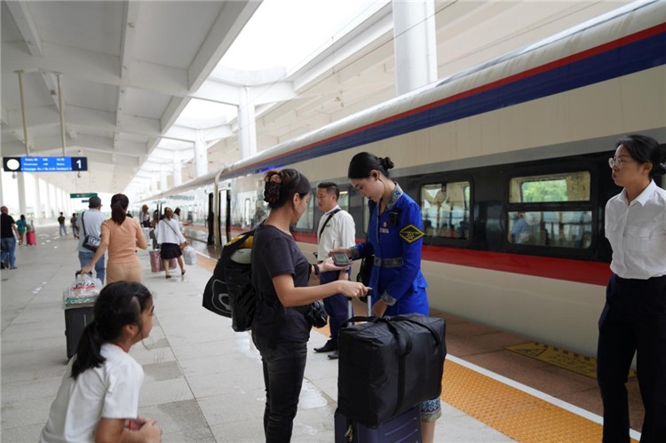 中老鐵路工作人員在站臺(tái)指引旅客進(jìn)站乘車。老中鐵路有限公司供圖