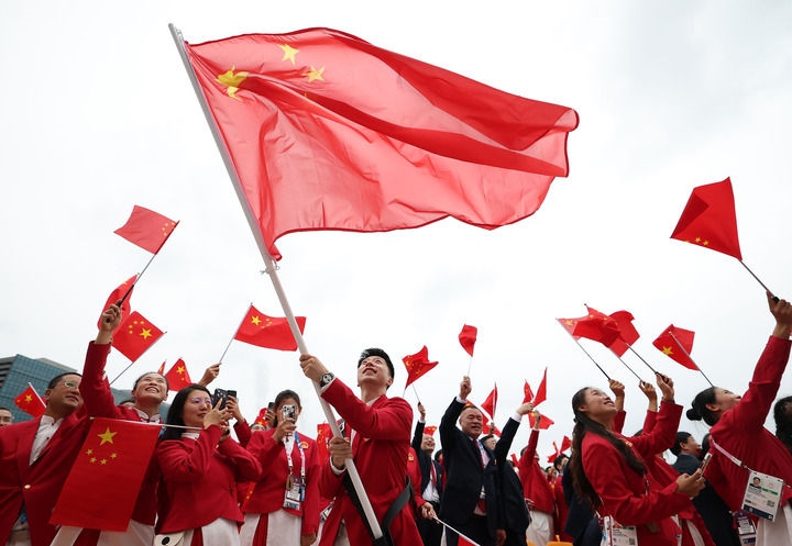 2024年7月26日，在法國巴黎舉行的第33屆夏季奧林匹克運(yùn)動會開幕式正式開始前，中國體育代表團(tuán)旗手揮舞國旗。新華社記者 曹燦 攝