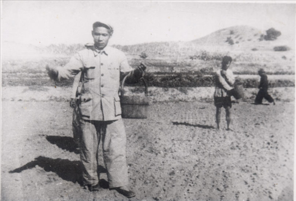 谷文昌（左）在田間與農(nóng)民一起勞動(dòng)（資料照片）。