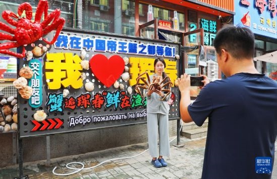 9月21日，游客在吉林省琿春市一處帝王蟹元素主題裝飾前拍照留念。新華社發(fā)