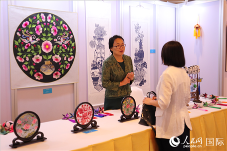 青海非遺文化傳承人向嘉賓介紹展品。人民網(wǎng)實(shí)習(xí)生姚欣可攝