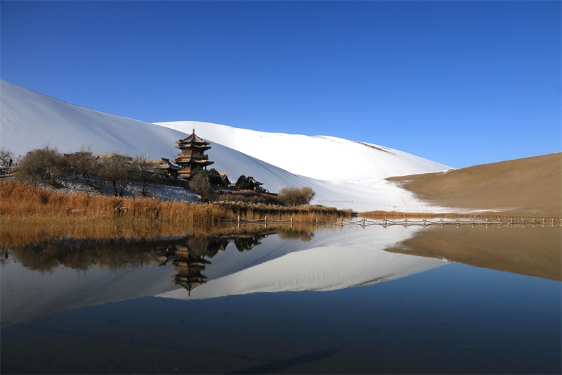 鳴沙山月牙泉景區(qū)雪景。敦煌市委宣傳部供圖，張曉亮攝