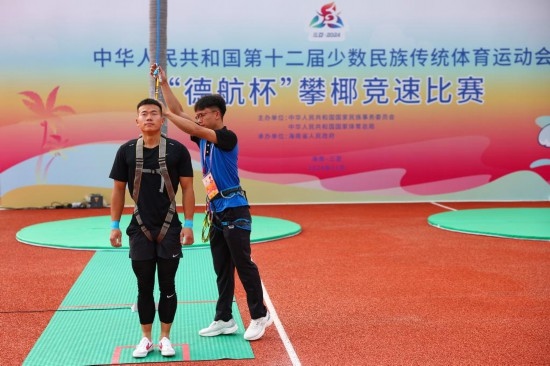 11月23日，工作人員為上海隊(duì)選手付樂樂（左）系安全繩。新華社記者 楊植森 攝