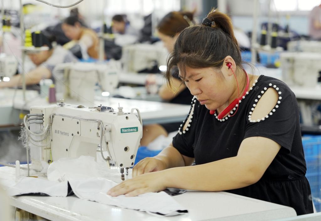 5月20日，村民在李寨村服裝加工廠內(nèi)忙碌。河南省周口市沈丘縣馮營鎮(zhèn)李寨村地處豫東平原。近年來，乘著脫貧攻堅(jiān)與鄉(xiāng)村振興政策的東風(fēng)，李寨村積極探索產(chǎn)業(yè)發(fā)展模式，通過“龍頭企業(yè)+村集體經(jīng)濟(jì)+農(nóng)戶”的方式，逐漸發(fā)展形成肉牛養(yǎng)殖、設(shè)施農(nóng)業(yè)、服裝加工、康養(yǎng)民宿等產(chǎn)業(yè)，以產(chǎn)業(yè)振興助力鄉(xiāng)村振興。新華社記者 李嘉南 攝