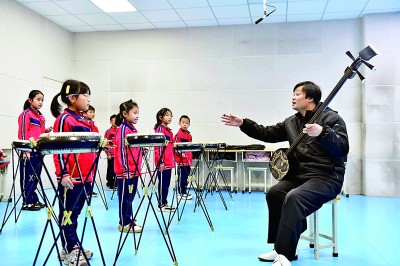 圖為12月30日，在惠民縣胡集鎮(zhèn)第一小學(xué)，老師指導(dǎo)學(xué)生學(xué)習(xí)西河大鼓。新華社記者 郭緒雷攝