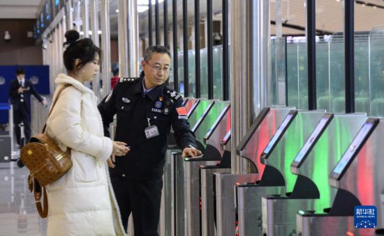 1月2日，大興機場邊檢站警察指導(dǎo)旅客使用自助出境設(shè)備。新華社記者 李欣 攝