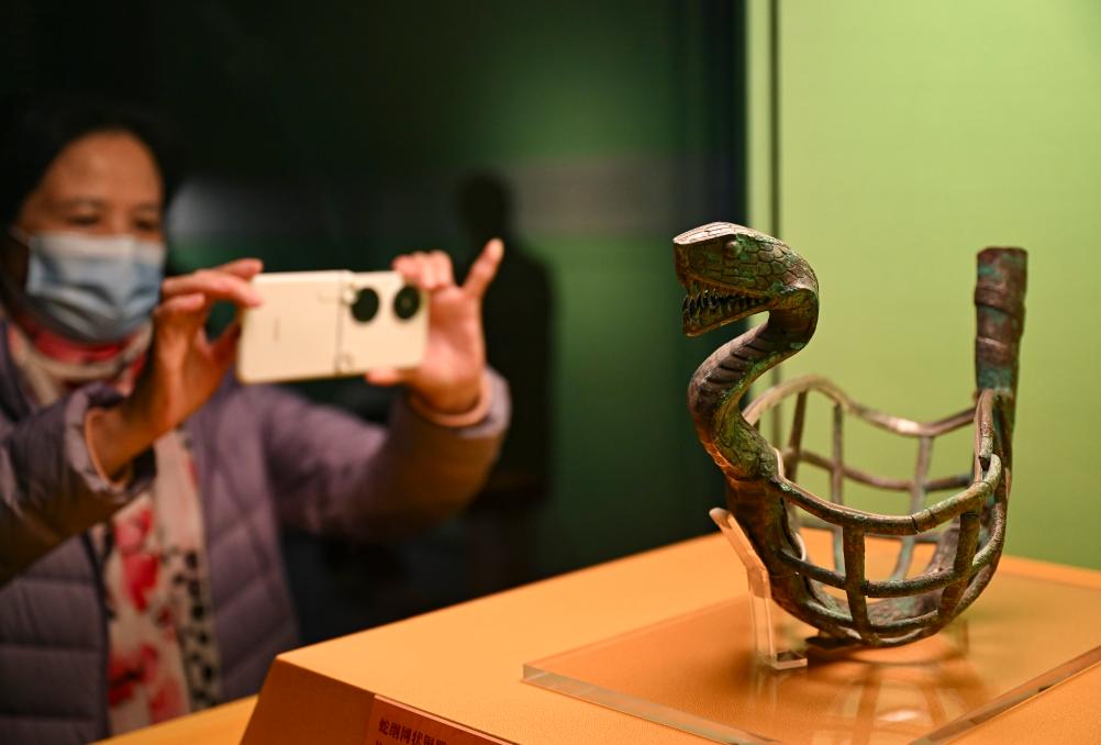 1月14日，觀眾在上海博物館蛇年迎春展拍攝展品蛇綱網(wǎng)狀銅器。新華社發(fā)（陳浩明攝）