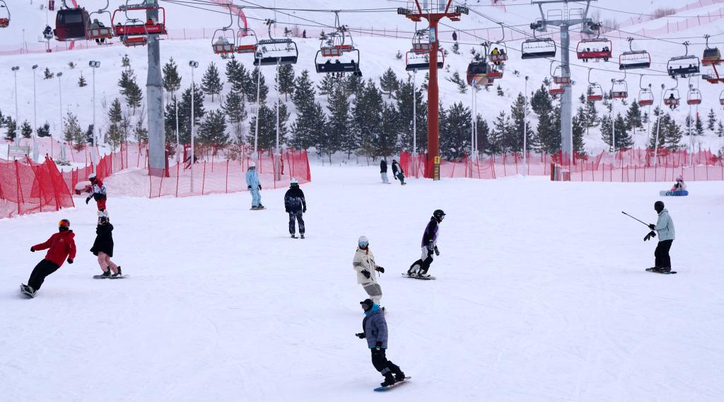 2025年1月8日，滑雪愛好者在新疆阿勒泰市將軍山滑雪場(chǎng)的雪道上滑行。新華社記者 張嘯誠(chéng) 攝