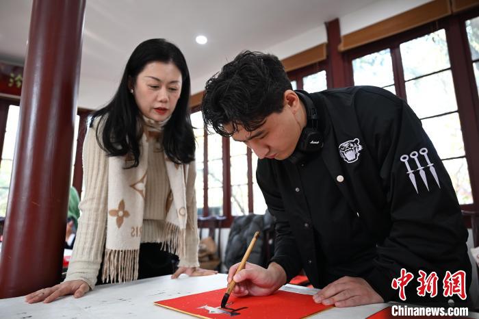1月20日，外籍留學(xué)生在西泠印社社員李硯指導(dǎo)下寫(xiě)福。當(dāng)日，來(lái)自巴西、馬來(lái)西亞、加納、哈薩克斯坦的外籍留學(xué)生在浙江杭州西泠印社體驗(yàn)福貼、春聯(lián)和篆刻，感受古老的中國(guó)傳統(tǒng)文化。中新社記者 王剛 攝