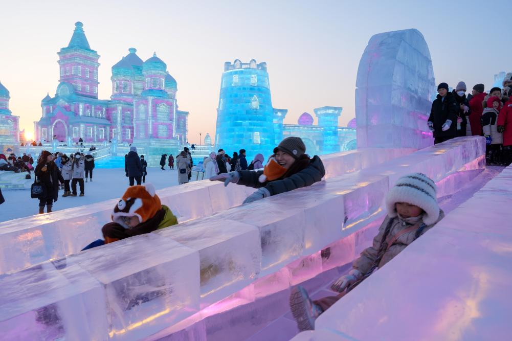 游客在哈爾濱冰雪大世界園區(qū)內體驗冰滑梯。新華社發(fā)