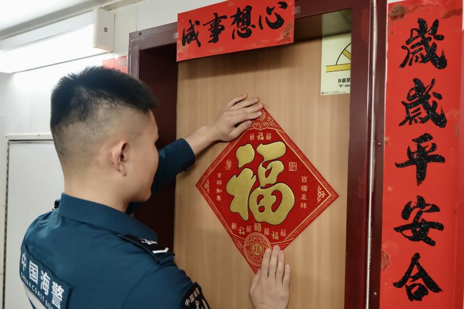 1月27日，在中國(guó)海警海鷗艦上，執(zhí)法員貼春聯(lián)福字慶祝農(nóng)歷春節(jié)。