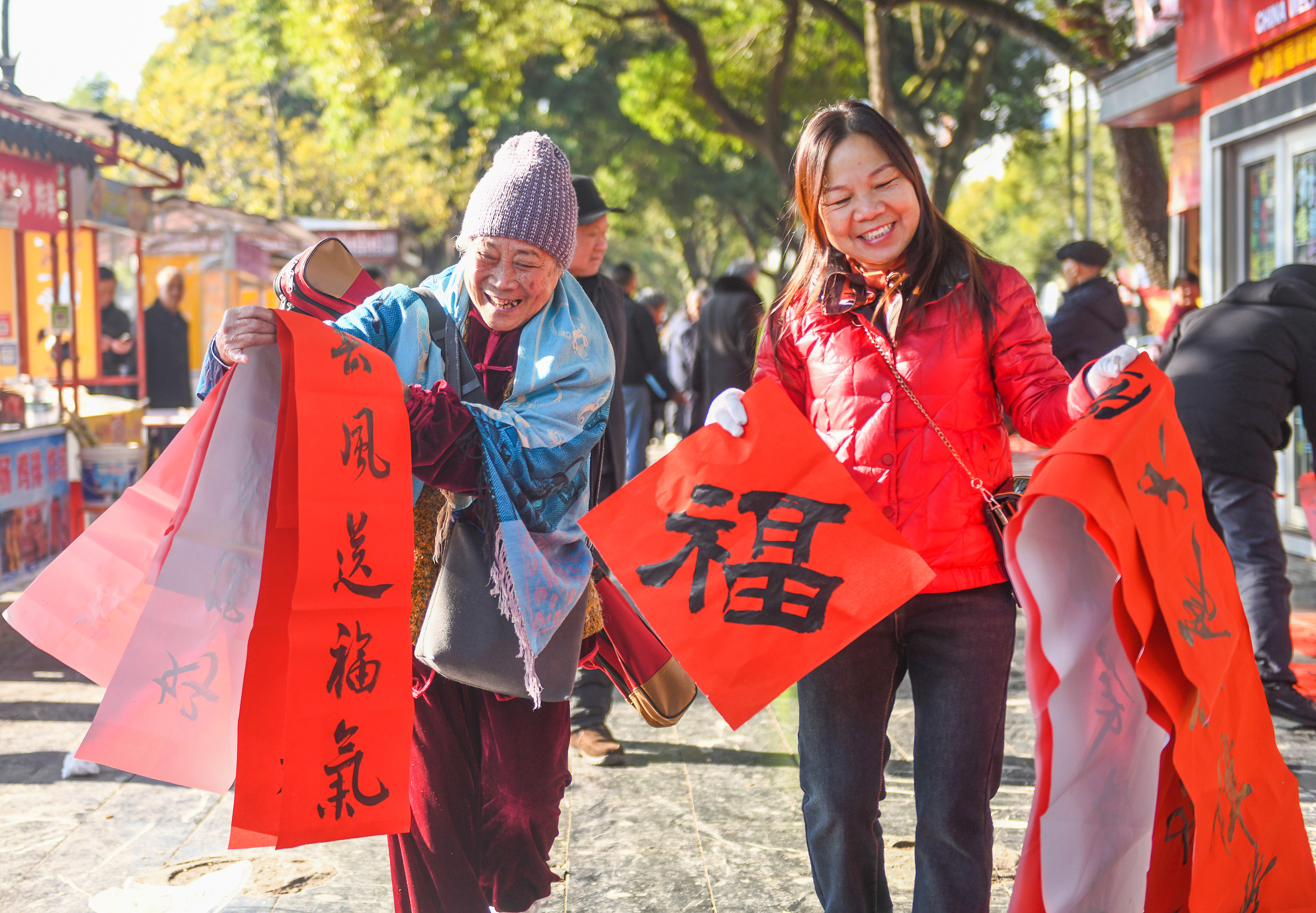 2025年1月13日，在湖南省永州市道縣西洲公園義工崗亭，市民們領到了書法志愿者為大家書寫的春聯。