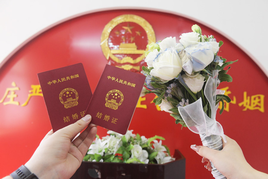2024年8月10日，一對新人在河北石家莊新樂市民政局婚姻登記處領取結婚證后拍照留念。新華社發(fā)（賈敏杰攝）