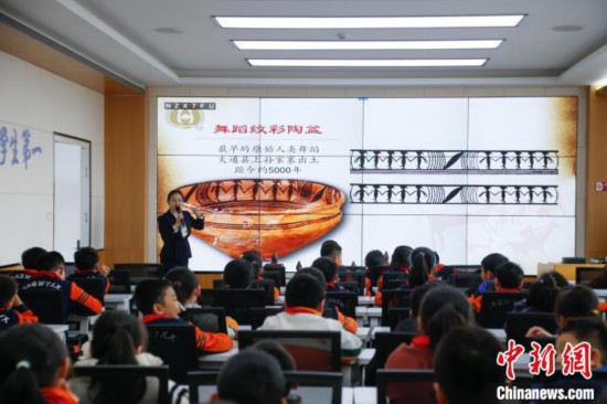 圖為學(xué)生在“國寶音樂會(huì)”社教課中了解舞蹈紋彩陶盆。中新社記者 馬銘言 攝