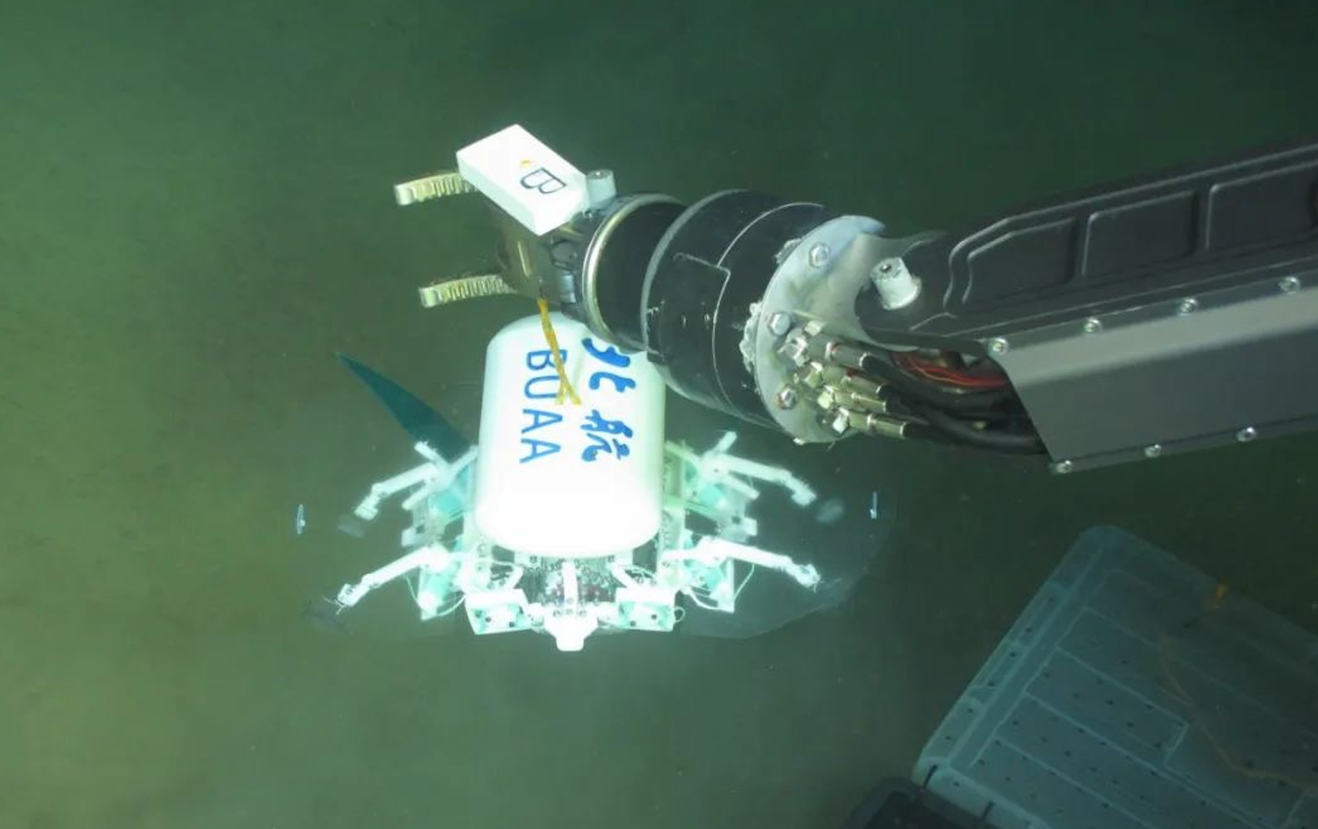 科研人員利用機械臂將北航深海小型機器人投于馬里亞納海溝。校方供圖