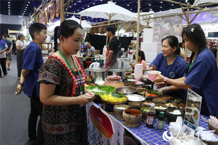 游客在攤位前購買特色美食。朱瀟逸攝