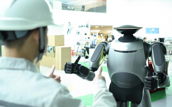 在廣汽研究院，人形機(jī)器人團(tuán)隊的周仁義在演示GoMate機(jī)器人互動功能（新華社記者 鄧華 攝）