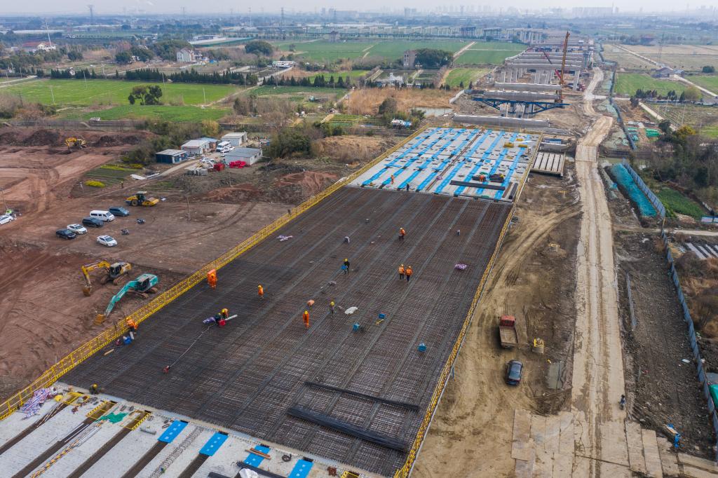 3月7日，在524國道秀洲王江涇至新塍公路工程TJ02標(biāo)段，作業(yè)人員正在進(jìn)行60米鋼混組合梁現(xiàn)澆橋面板鋼筋焊接及綁扎作業(yè)（無人機(jī)照片）。新華社記者 徐昱 攝