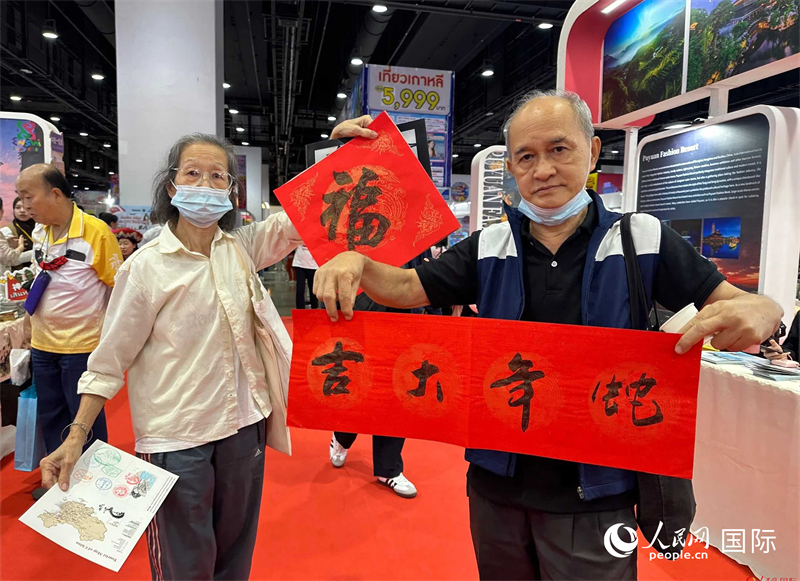2025蛇年春節(jié)，泰國(guó)市民展示他們領(lǐng)到的華人手寫春聯(lián)。人民網(wǎng)記者 簡(jiǎn)承淵攝