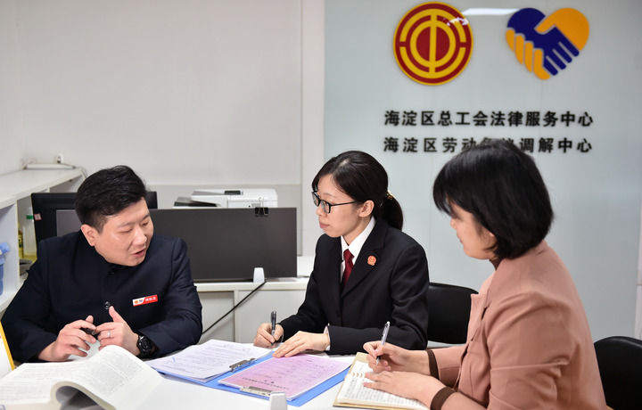 2025年3月6日，在北京市海淀區(qū)總工會勞動爭議調(diào)解中心，海淀區(qū)人民法院法官王琰（中）與該中心工作人員就糾紛化解情況進(jìn)行溝通。新華社記者 趙婷婷 攝