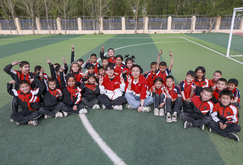 4月23日，在新疆克州阿圖什市哈拉峻鄉(xiāng)謝依特小學(xué)，支教教師王俊文（中左）、李軻凡（中右）和學(xué)生在一起。