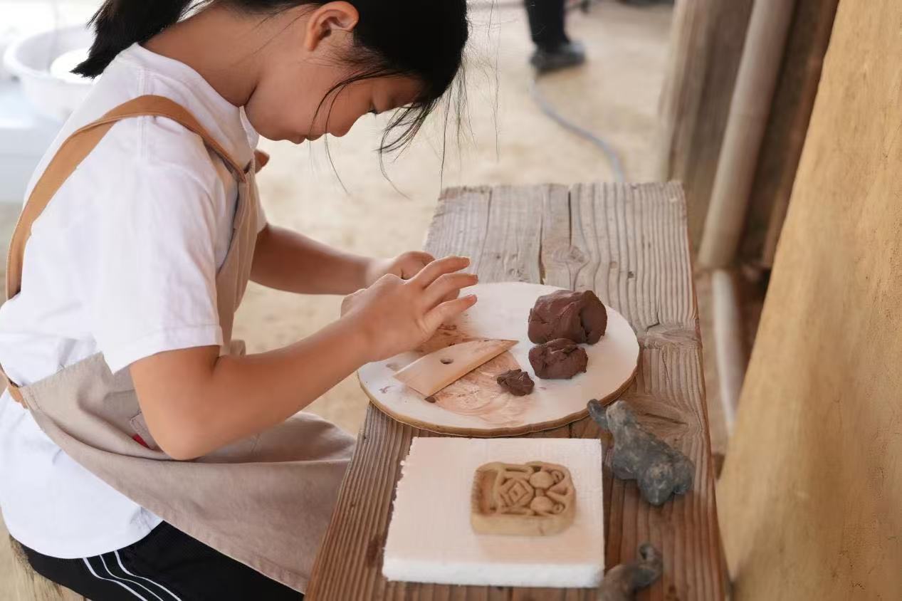 游客制作良渚特色陶藝品。良渚博物院供圖