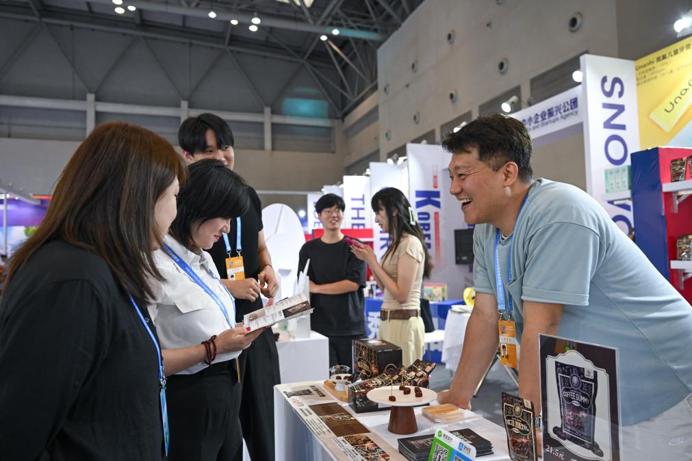 5月22日，韓國展商（右一）在西洽會(huì)現(xiàn)場向參觀者介紹產(chǎn)品。新華社記者 陳誠 攝