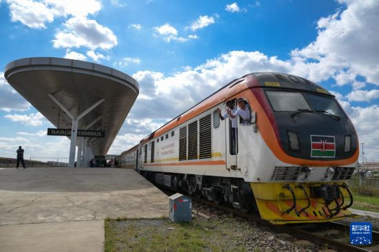 5月31日，在蒙內(nèi)鐵路內(nèi)羅畢站，機車駕駛員蔣立平（右）和博爾在即將開往蒙巴薩的E2次列車上揮手致意。新華社記者 楊光 攝
